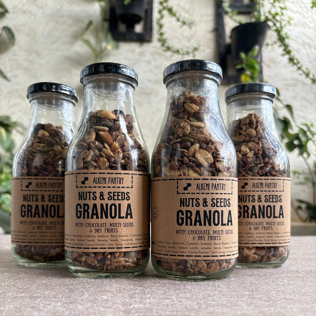 Four bottles of granola with visible labels against a neutral background